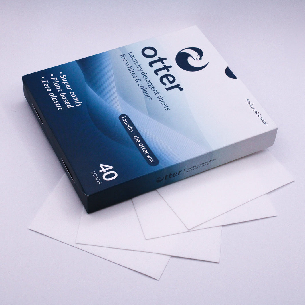 Box of Otter paper with some sheets on a light gray background