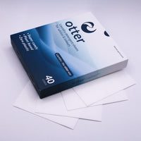 Box of Otter paper with some sheets on a light gray background